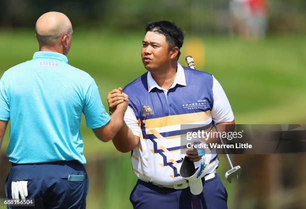 Kiradech Aphibarnrat of Thailand shakes hands with Graeme Storm of England on the 18th green during day one of the BMW PGA Championship at Wentworth...