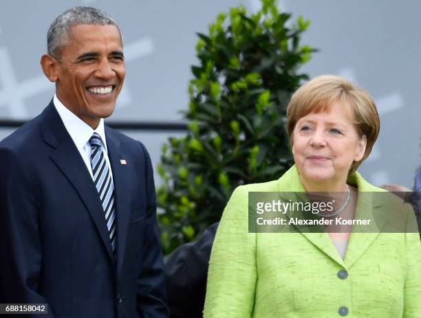 Former President of the United States of America, Barack Obama and German Chancellor Angela Merkel walk on stage at the Brandenburg Gate during the...