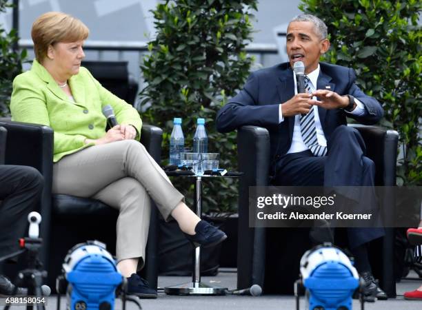 Former President of the United States of America, Barack Obama and German Chancellor Angela Merkel speak on stage at the Brandenburg Gate during the...