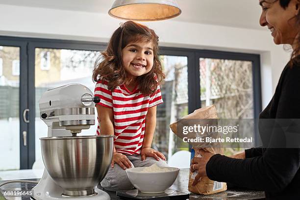 girl helping mother with baking - bjarte rettedal stock pictures, royalty-free photos & images