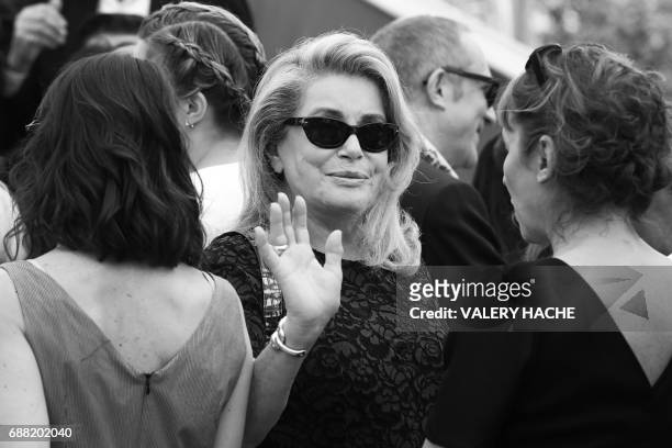 French actress Catherine Deneuve waves while attending on May 23, 2017 a photocall for the '70th Anniversary' of the Cannes Film Festival in Cannes,...