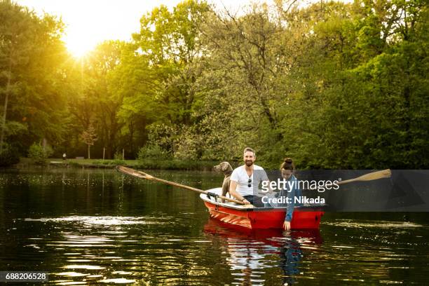 père, fille et chien en barque sur le lac - bateau à rames photos et images de collection