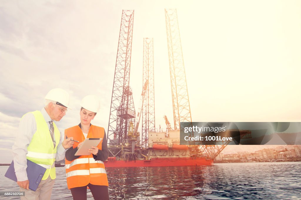 Attractive young female engineer and her boss, Offshore construction platform