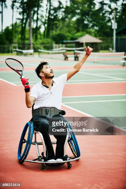 Adaptive athlete serving while playing wheelchair tennis