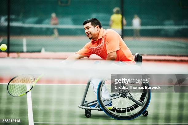 Adaptive athlete stretching for forehand shot during wheelchair tennis match