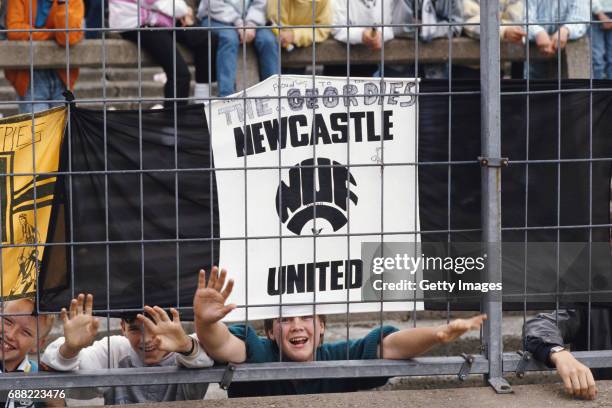 Newcastle United fans hang their flags to the safety fence surrounding the pitch before a First Division match against Liverpool at St James' Park on...