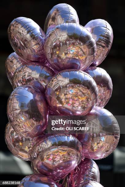 Flowers and messages of support are refelcted in balloons in St Ann's Square in Manchester, northwest England on May 25 placed in tribute to the...