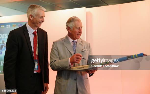 The Prince of Wales signs a bat as Steve Elworthy of the ICC looks on as he launches the ICC Champions The ICC Champions Trophy at The Oval on May...