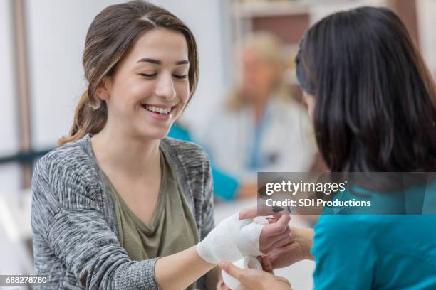 nurse wraps patient's injured hand - emergency medicine stock pictures, royalty-free photos & images