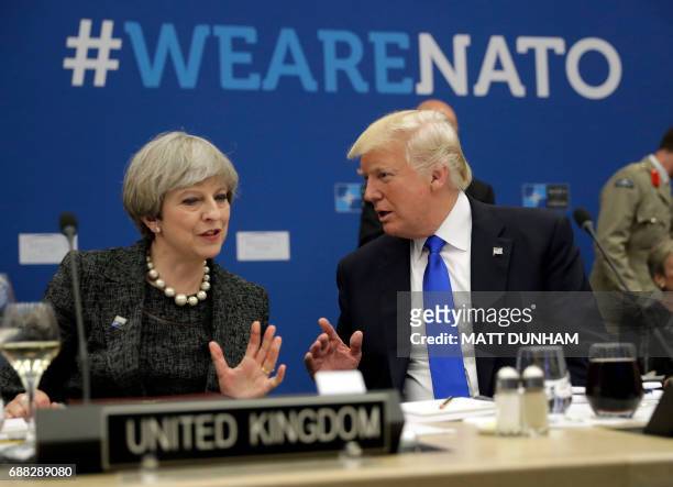 President Donald Trump speaks with British Prime Minister Theresa May during in a working dinner meeting at the NATO summit at the NATO headquarters,...