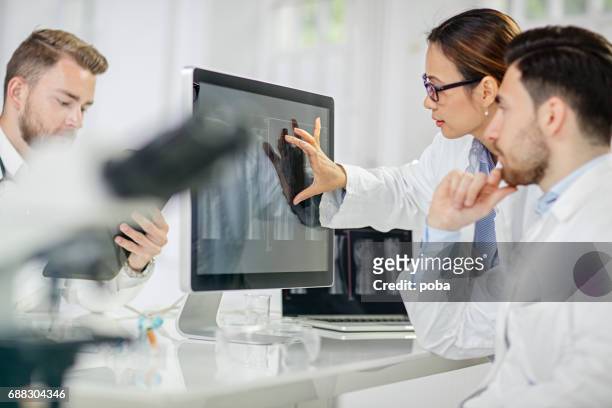 radioloog x-ray afbeelding op de computer te onderzoeken - doctor lab coat stockfoto's en -beelden