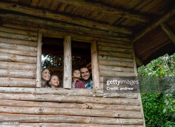 famille latine, regardant par la fenêtre d’une maison de campagne - chalet de montagne photos et images de collection