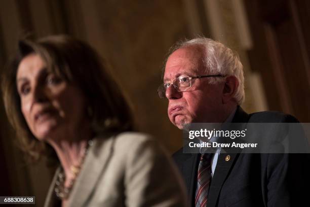 House Minority Leader Nancy Pelosi speaks as Sen. Bernie Sanders looks on during a press conference to discuss legislation for a 15 dollar minimum...