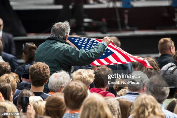 Participant of the Protestant Kirchentag weaves a US flag during a discussion between former US president Barack Obama and German Chancellor Angela...