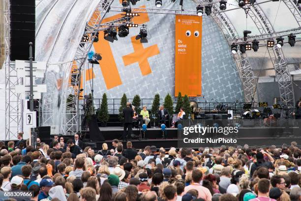 Participants of the Protestant Kirchentag listen to the discussion between former US president Barack Obama and German Chancellor Angela Merkel about...