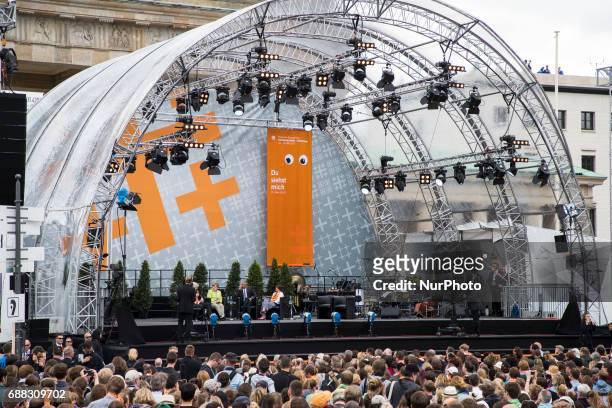 Participants of the Protestant Kirchentag listen to the discussion between former US president Barack Obama and German Chancellor Angela Merkel about...