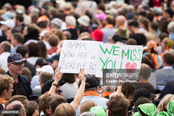 Participants of the Protestant Kirchentag hold banners reading 'Obama you are a Berliner' and 'we miss you' as they await to attend the discussion...