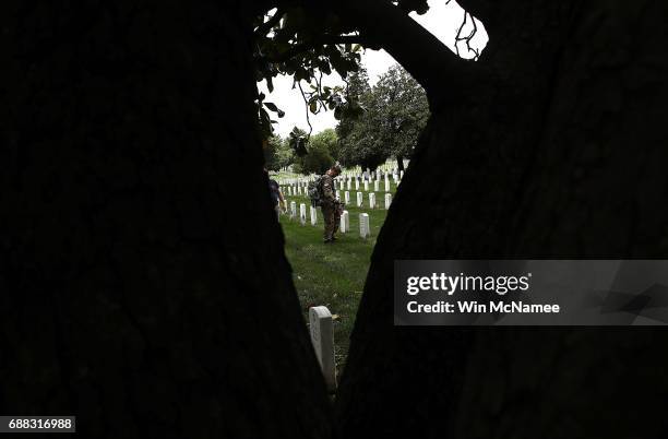 Members of the 3rd U.S. Infantry Regiment place flags at the headstones of U.S. Military personnel buried at Arlington National Cemetery, in...