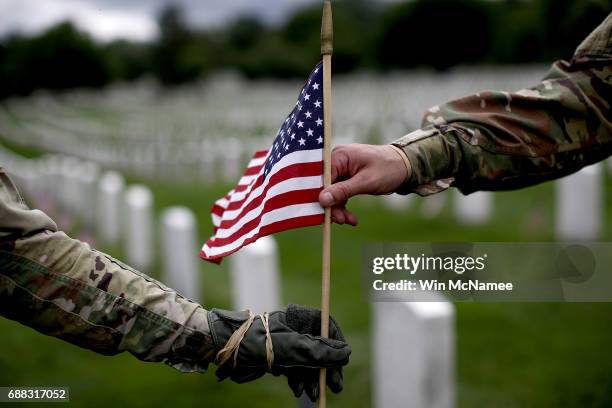 Sgt. Iwona Kosmaczewska and Pvt. 2 Wesley Defee , members of the 3rd U.S. Infantry Regiment, place flags at the headstones of U.S. Military personnel...