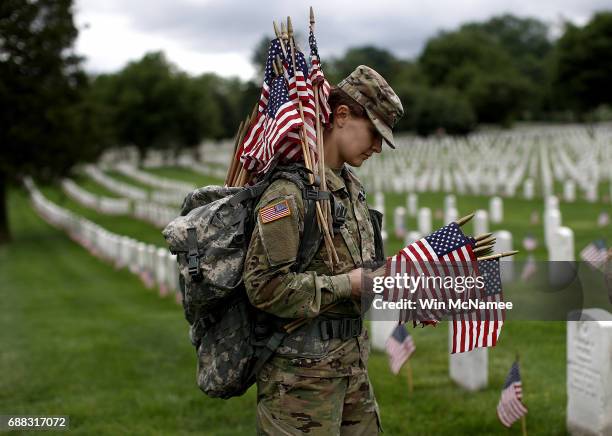 Sgt. Iwona Kosmaczewska assists with the process of placing flags at the headstones of U.S. Military personnel buried at Arlington National Cemetery...