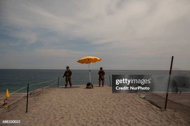 Italian soldiers stand guard on the beach near the Media Center of the G7 in the sicilian town of Giardini Naxos, southern Italy on May 25, 2017....