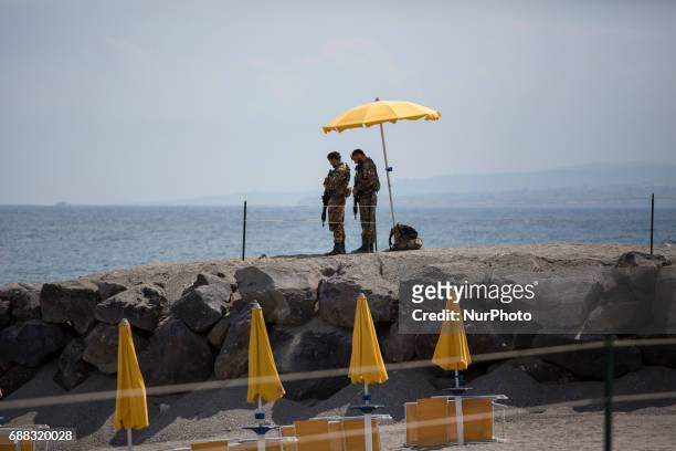 Italian soldiers stand guard on the beach near the Media Center of the G7 in the sicilian town of Giardini Naxos, southern Italy on May 25, 2017....