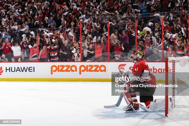 Craig Anderson of the Ottawa Senators takes a knee as fans react to their win against the Pittsburgh Penguins in Game Six of the Eastern Conference...