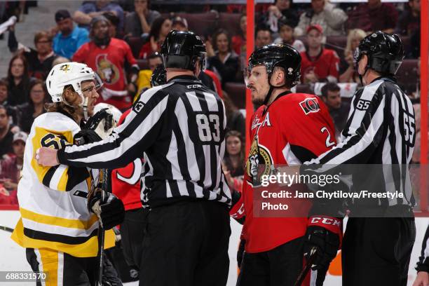 Linesmen Matt MacPherson and Pierre Racicot separate Dion Phaneuf of the Ottawa Senators and Carl Hagelin of the Pittsburgh Penguins in Game Six of...