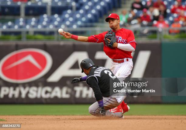 Cesar Hernandez of the Philadelphia Phillies attempts to turn a double-play in the fourth inning during a game against the Colorado Rockies at...
