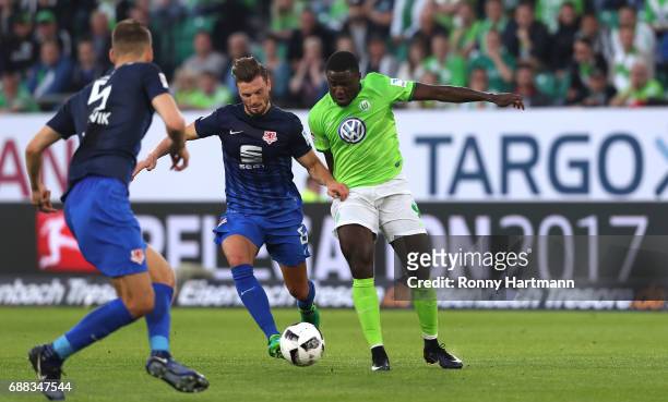 Paul-Georges Ntep of Wolfsburg vies with Gustav Valsvik of Braunschweig during the Bundesliga Playoff first leg match between VfL Wolfsburg and...