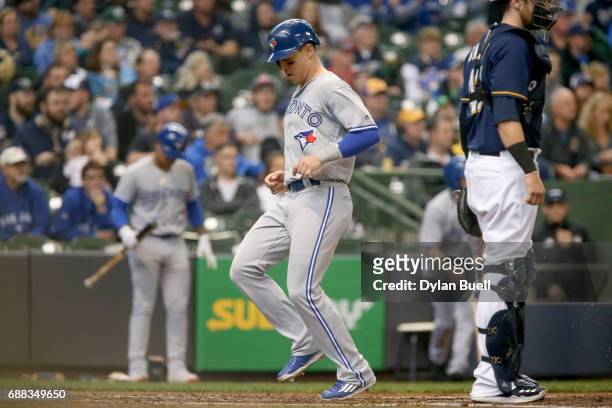 Chris Coghlan of the Toronto Blue Jays scores a run past Jett Bandy of the Milwaukee Brewers in the fifth inning at Miller Park on May 24, 2017 in...