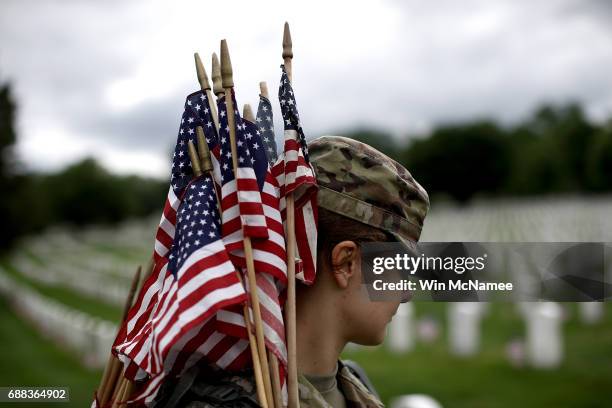 Sgt. Iwona Kosmaczewska assists with the process of placing flags at the headstones of U.S. Military personnel buried at Arlington National Cemetery...