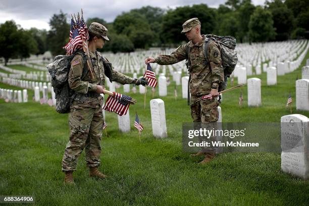 Sgt. Iwona Kosmaczewska and Pvt. 2 Wesley Defee , members of the 3rd U.S. Infantry Regiment, place flags at the headstones of U.S. Military personnel...