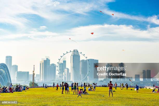 singapore - august 14, 2016 : peoples enjoy outdoor holiday activities at singapore marina barrage park with singapore city background near marina bay - singapore foto e immagini stock