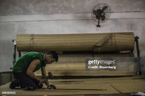 Worker marks a carpet made from sisal fiber yarn at the Association for Sustainable and Solidarity Development of the Sisal Region facility in the...