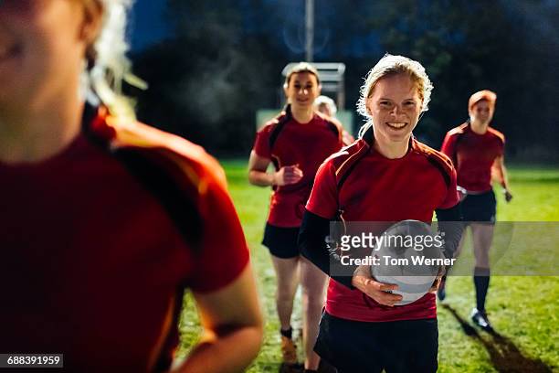 female rugby team running together - women rugby stock pictures, royalty-free photos & images