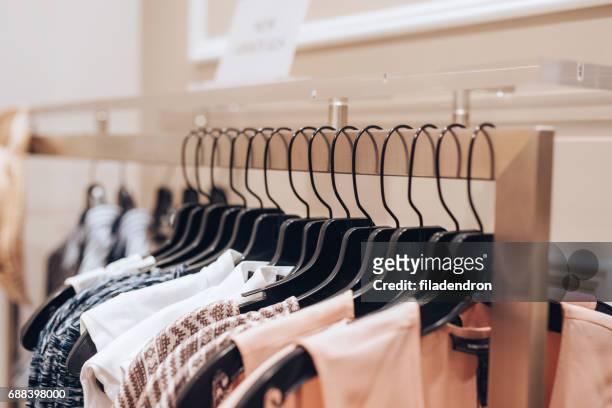 abiti impiccati in un negozio di abbigliamento - vestito da sera femminile foto e immagini stock