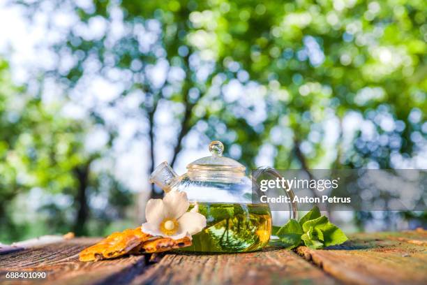 tea pot of herbal tea on a wooden table - mint tea stock pictures, royalty-free photos & images