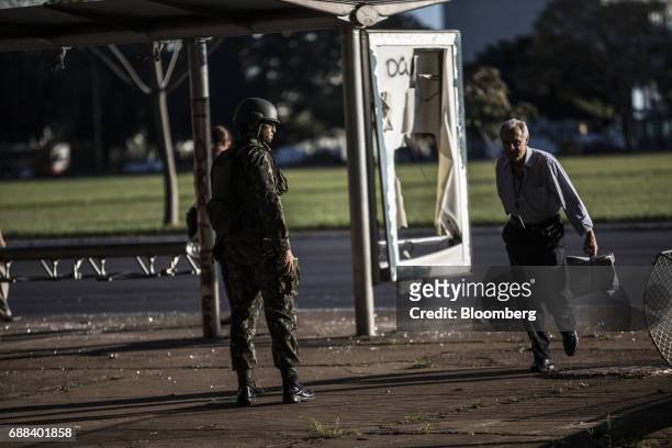 Federal army soldier stands guard in front of a destroyed bus station in Brasilia, Brazil, on Thursday, May 25, 2017. President Michel Temer...