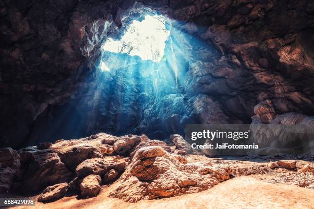 light rays coming inside the khao luang cave. khao luang cave at phetchaburi, thailand - luce alla fine del tunnel foto e immagini stock