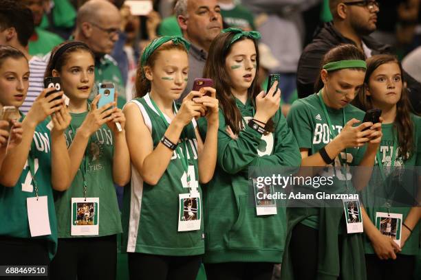 Young Boston Celtics fans use their phones prior to Game Five of the 2017 NBA Eastern Conference Finals between the Cleveland Cavaliers and the...