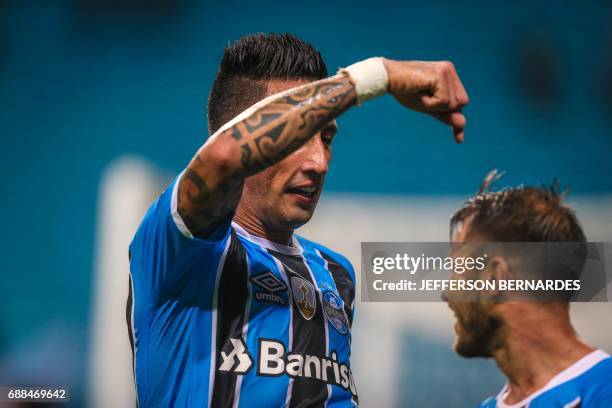 Lucas Barrios of Gremio celebrates with Gaston Fernandez after scoring against Venezuela's Zamora during their Copa Libertadores football match at...