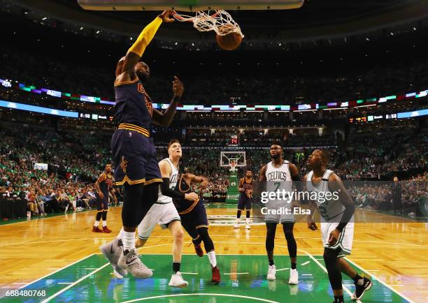 LeBron James of the Cleveland Cavaliers dunks in the first half as Jaylen Brown and Terry Rozier of the Boston Celtics defend during Game Five of the...