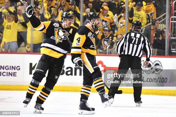 Justin Schultz of the Pittsburgh Penguins celebrates with his teammate Evgeni Malkin after scoring a goal against Craig Anderson of the Ottawa...