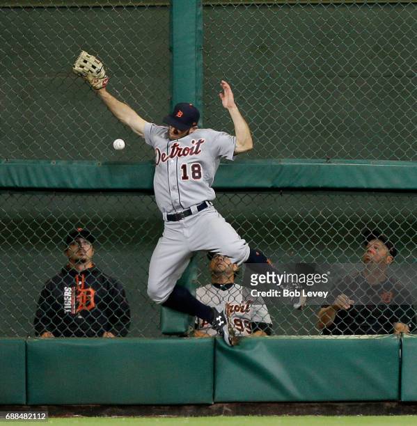 Tyler Collins of the Detroit Tigers leaps at the wall but has the ball go off the palm of his glove on a deep fly off the bat of Evan Gattis of the...