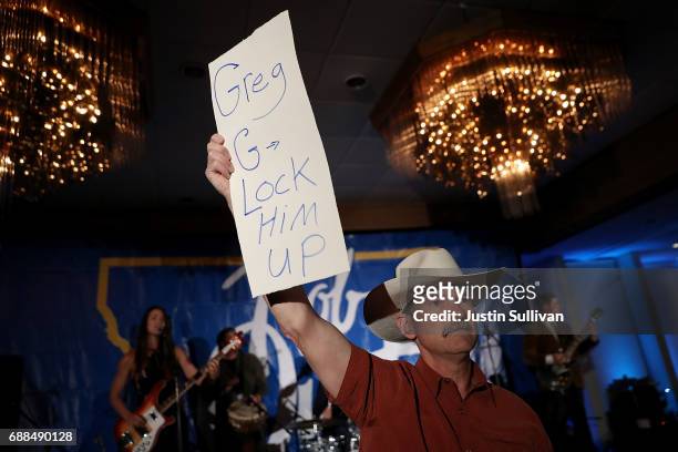 Supporter of Democratic U.S. Congresstional candidate Rob Quist holds a sign that refers to Republican candidate Greg Gianforte during an election...