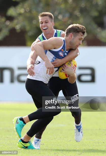 Shaun Higgins of the Kangaroos is tackled by Andrew Swallow of the Kangaroos during a North Melbourne Kangaroos AFL training session at Arden Street...