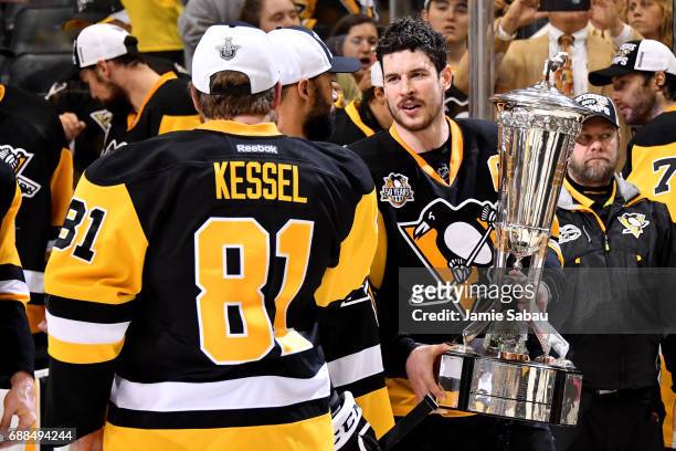 Sidney Crosby of the Pittsburgh Penguins talks with Phil Kessel as he holds the Prince of Wales Trophy after winning Game Seven of the Eastern...