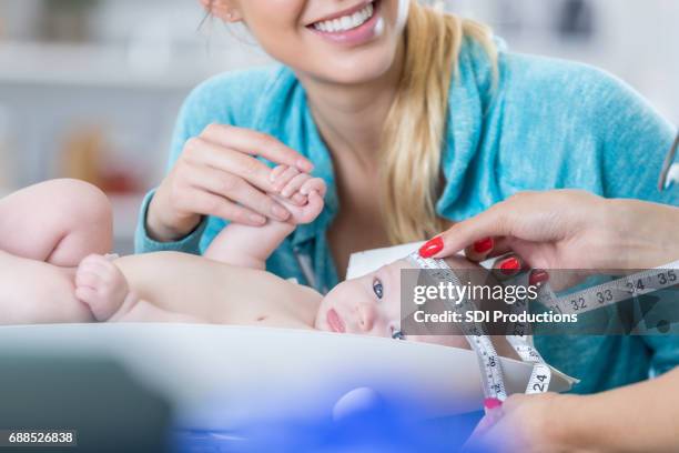 nurse checks baby's head circumference - circle of heads stock pictures, royalty-free photos & images