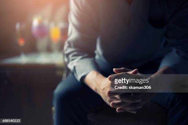 very tired or stressed businessman hand touching head and sitting in front of cocktail and alcohol drink with darken mood and tone - stressed businessman stock pictures, royalty-free photos & images